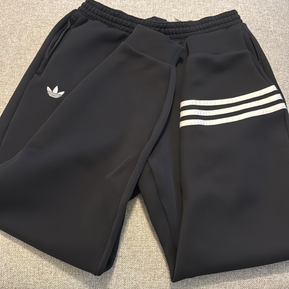 Adidas black joggers with zipper pockets and 3 stripes on bottom of one leg - Picture 3 of 4